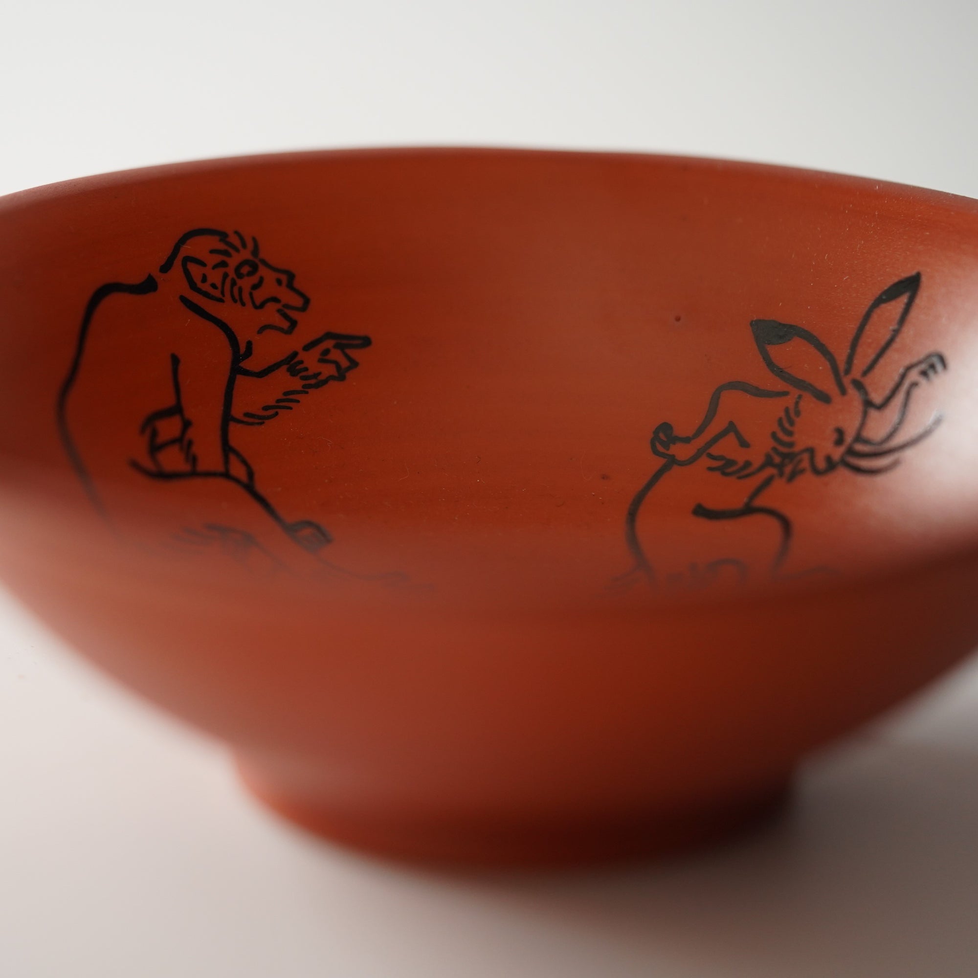 Small flower-shaped bowl with caricatures of birds and animals, red scroll